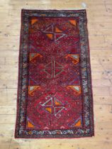 A hand knotted Turkish oushak rug, the red ground with geometric design and bordered 101cm x 190cm