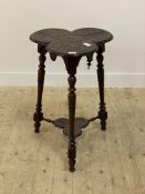 A late Victorian carved oak occasional table, the trefoil top raised on ring turned supports