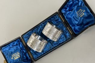 A pair of Edwardian Epns engraved napkin rings with family crest complete with original case