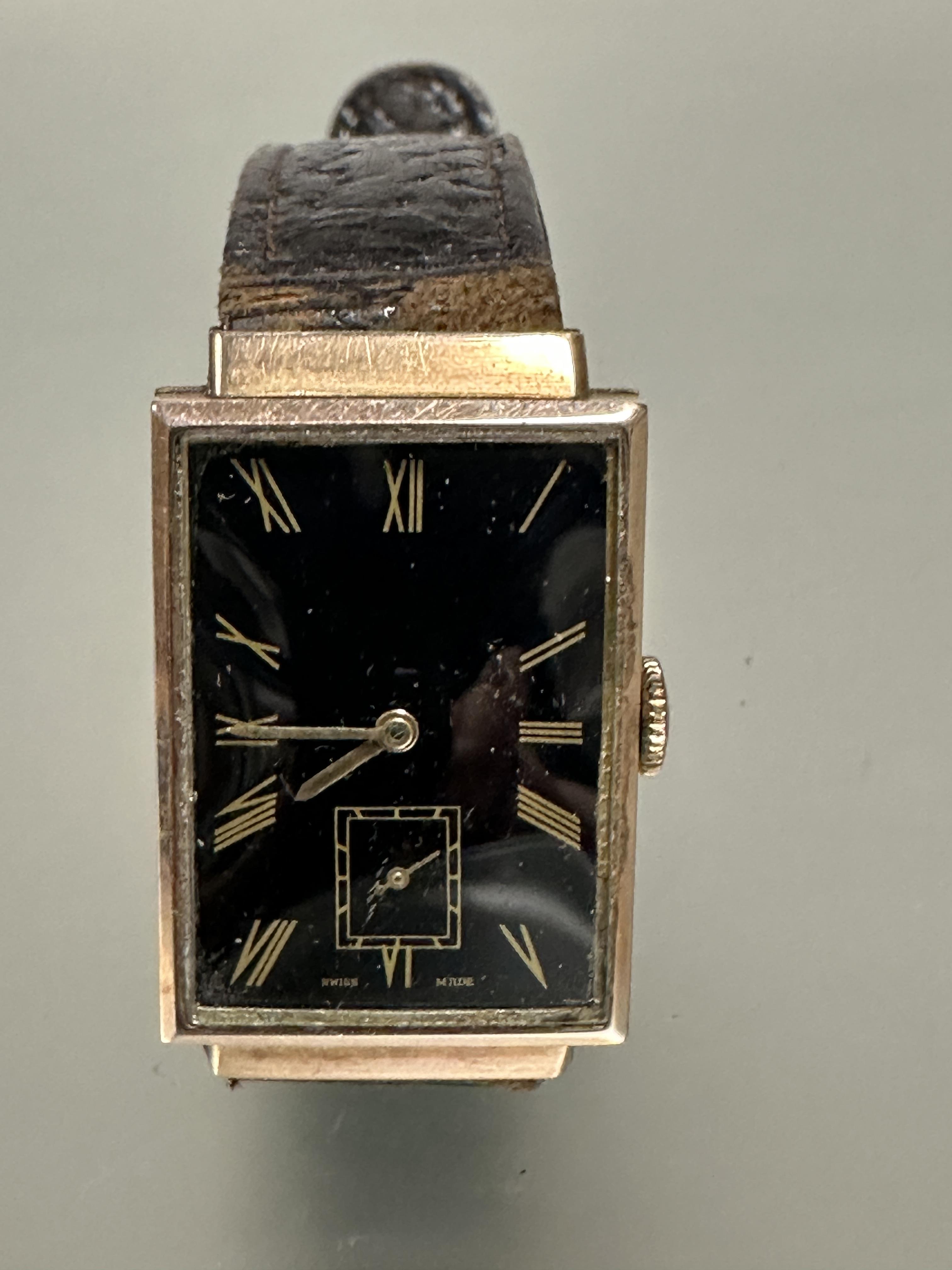 A gents 9ct gold cased 1930s Tank shaped wristwatch with black enamel dial and gilt roman numerals