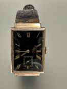 A gents 9ct gold cased 1930s Tank shaped wristwatch with black enamel dial and gilt roman numerals