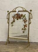 A Cast brass Art Nouveau period fire screen, the bevelled mirror panel painted with floral sprigs