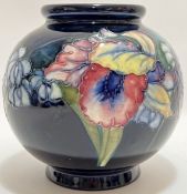 William Moorcroft, an Iris/Wild Flowers pattern globular vase decorated with with flowers on a