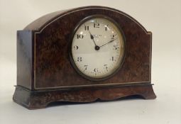 A 1930's mantel clock, the domed yew wood case with ivorine string inlay enclosing a white enamel
