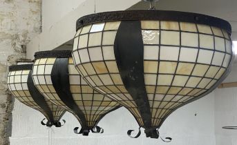 A set of three large lead glazed slag glass pendent light fittings of compressed form, with floral