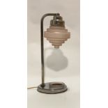An Art Deco period table lamp of characteristic form, the pink stepped cylindrical glass shade on