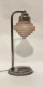 An Art Deco period table lamp of characteristic form, the pink stepped cylindrical glass shade on