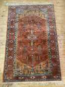 A hand knotted Kurdish / Turkmen rug, the orange field with geometric stylised foliate, with guls to