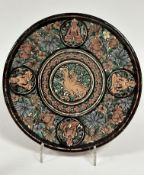 A Indonesian terracotta circular plaque with central bird figure enclosed within a lotus flower