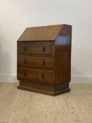 An Art Deco period oak bureau, the fall front opening to a fitted interior, above three drawers,