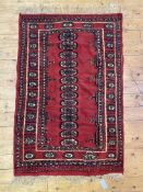 A hand knotted Afghan / Turkmen bokhara rug, the red field with single row of guls and bordered