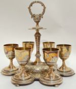An Elkington and Co silver plated egg cup holder with six egg cups, engraved and moulded design with
