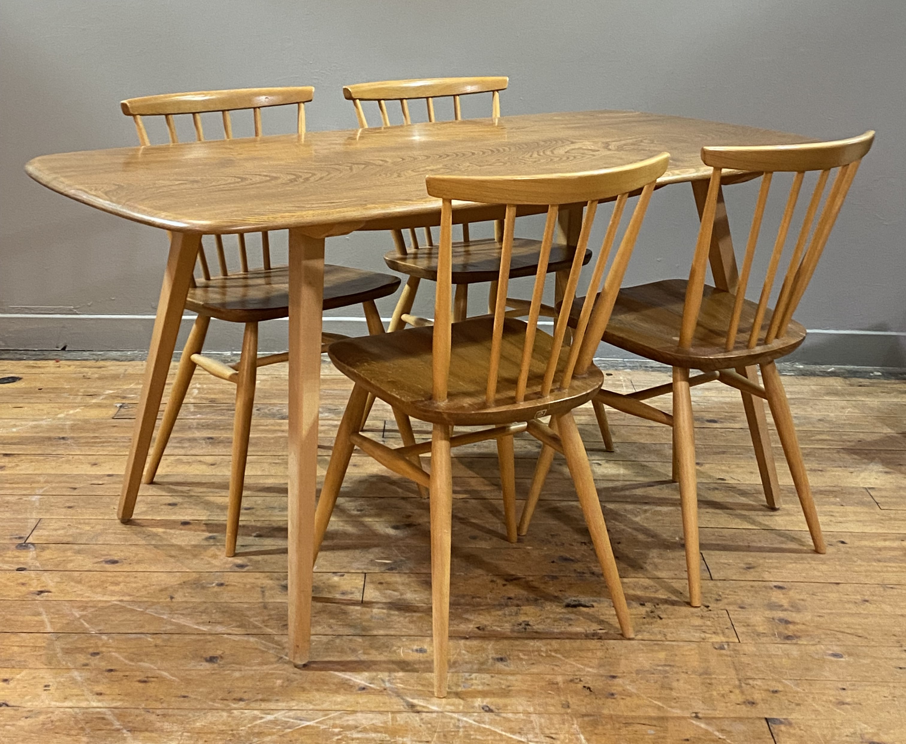 Ercol, A vintage dining suite, circa 1970's / 80's, comprising a dining table with shaped elm top