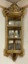 A gilt framed mirrored wall-hanging encoignure, early 19th century, the gesso and composition