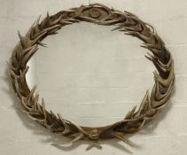 Clockhouse, a large oval wall hanging mirror, the elm frame mounted with deer antlers. 125cm x