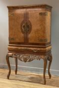 A birds eye maple-veneered cocktail cabinet on stand in the 18th century style, mid 20th century,