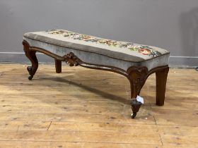 A Victorian walnut window seat, the needlework upholstered top worked in a floral design, above a