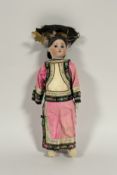A porcelain head doll dressed as a Chinese girl, c. 1900, probably English