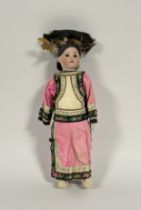 A porcelain head doll dressed as a Chinese girl, c. 1900, probably English