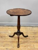 A George III mahogany wine table, the dished circular top over a turned column of urn form, raised