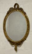 Charles Nosotti, A 19th century giltwood and gesso wall hanging mirror of oval outline, the frame