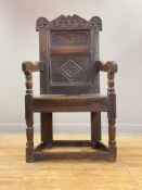 A 17th century oak Wainscot chair, of pegged and jointed construction, the crest rail carved with