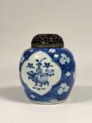 A Chinese blue and white ginger jar, painted with two shaped cartouches enclosing precious objects
