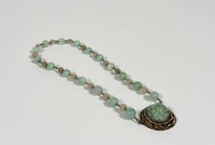 A Chinese jadeite single strand bead necklace, the uniform spherical celadon beads spaced by small g