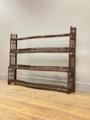 An Edwardian mahogany three tier wall hanging shelf of serpentine outline,