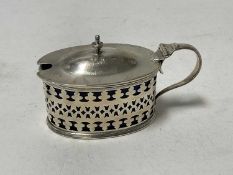 Edwardian silver mustard pot of oval form, with pierced decoration and blue glass liner, (London 190