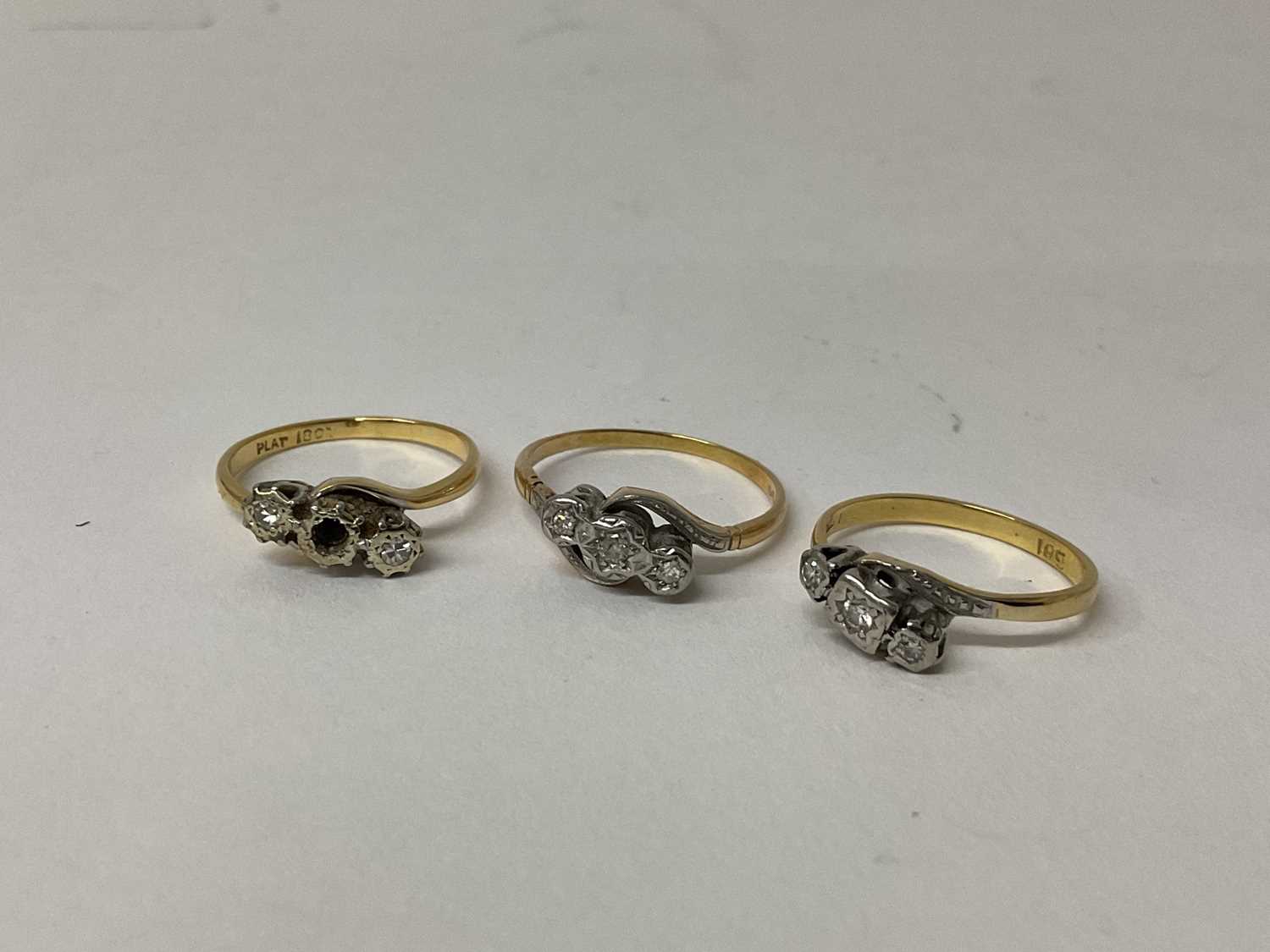 Three 18ct gold diamond three stone rings, each with three small diamonds in platinum illusion setti