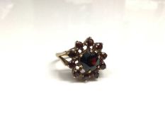 9ct gold garnet cluster ring with a flower head cluster of mixed cut garnets in gold claw setting on