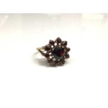 9ct gold garnet cluster ring with a flower head cluster of mixed cut garnets in gold claw setting on