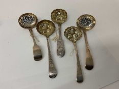 Group of five Georgian and later silver sifter ladles, three with later chased and embossed decorati