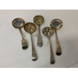 Group of five Georgian and later silver sifter ladles, three with later chased and embossed decorati