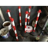 Six red and white weighted base posts and plastic chain