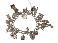 Silver charm bracelet with various silver and white metal novelty charms