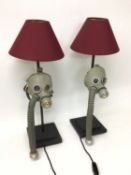 A pair of child's gas masks converted to table lamps, with blue LED lights fitted behind each eyepie