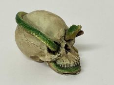 Small skull with snake running through its open mouth