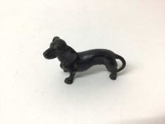 Antique carved wooden model of a Dachshund with painted eyes and naturalistically carved body, 9cm l