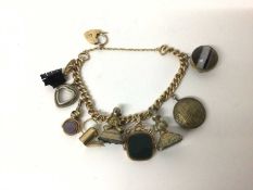 15ct gold curb link bracelet with a collection of antique gilt metal charms