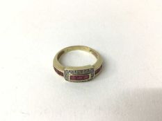 Ruby and diamond ring with a rectangular diamond bezel and a band of calibre cut rubies