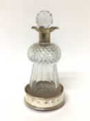 Silver mounted cut glass lidded thistle decanter, housed in a modern silver wine coaster