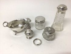Group of silver to include a silver topped cut glass sugar castor, sauce boat, pepperette, napkin ri