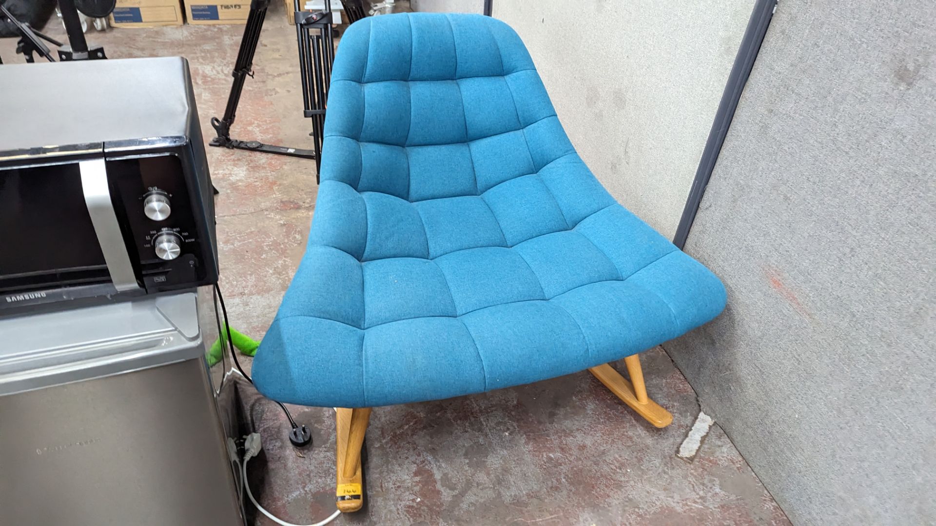 Rocking chair upholstered in aquamarine fabric on wooden legs