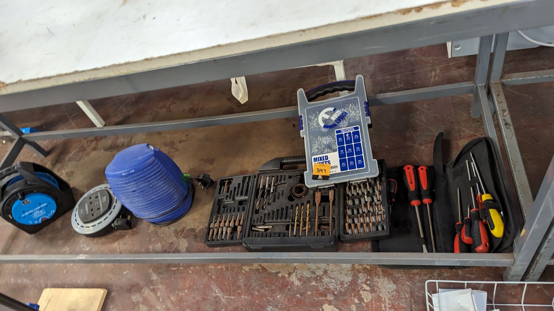 The contents of a bay of hand tools & electrical extension leads, including small fan heater