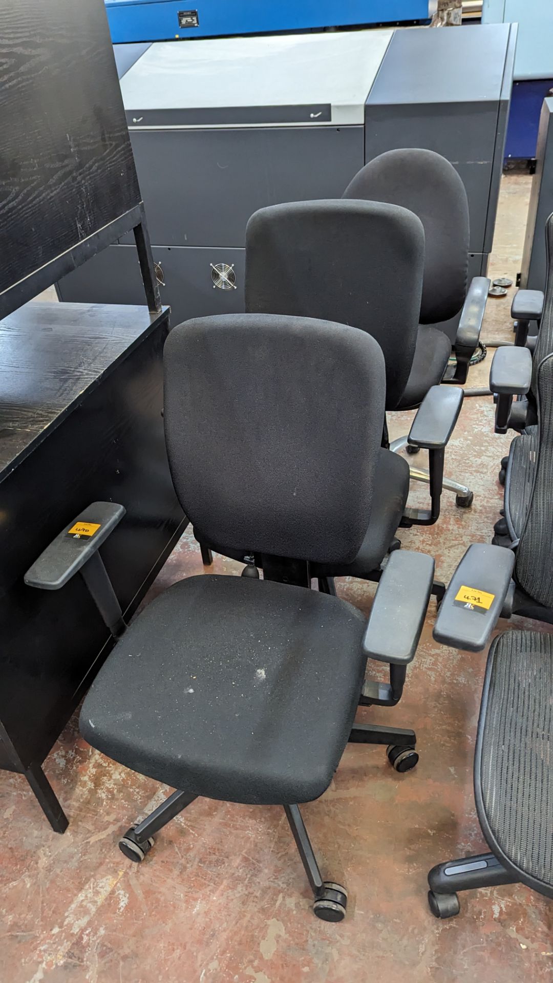 3 assorted black operators chairs with arms