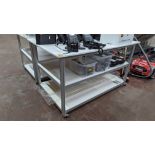 Mobile worktable with 2 shelves underneath the main work surface. Includes protective sheet in very