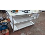 Mobile worktable with 2 shelves underneath the main work surface. Includes protective sheet in very