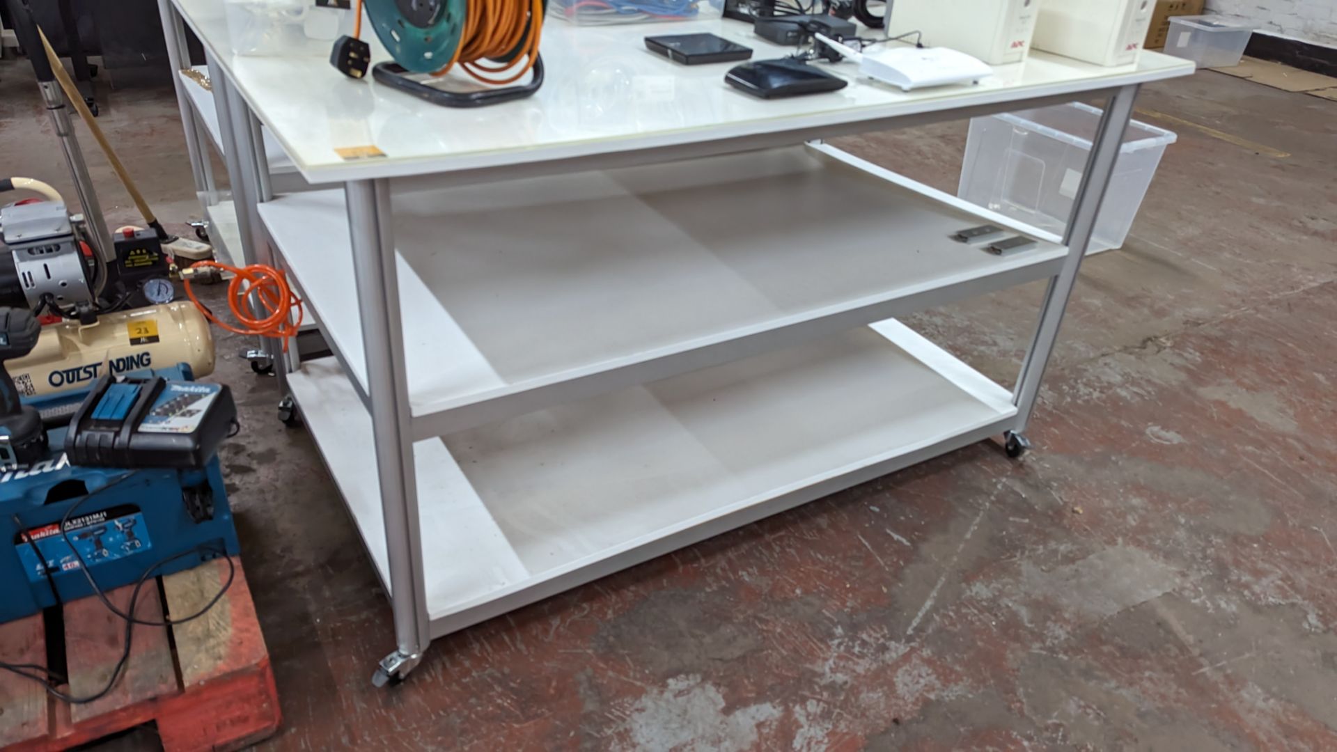 Mobile worktable with 2 shelves underneath the main work surface. Includes protective sheet in very